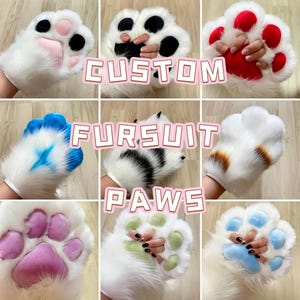 May include: A collage of nine plush white faux fur gloves designed as animal paws, each featuring distinctively coloured soft pads. The text CUSTOM FURSUIT PAWS is overlaid in the centre. The paw pads vary in colour, including pink, black, red, blue, purple, green, and light blue.