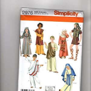 Könnte beinhalten: Simplicity Schnittmuster 2976 für historische Kostüme in den Größen XS, S, M und L. Die Hülle zeigt Illustrationen von sieben Figuren, die verschiedene Tuniken, Roben und rüstungsartige Outfits mit Kopfbedeckungen und Sandalen tragen.