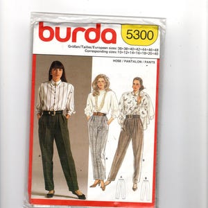 Puede incluir: Un patrón de costura Burda, modelo 5300, con ilustraciones de pantalones y blusas de mujer. El paquete incluye información de tallas en tallas europeas y correspondientes. La portada tiene el logo de Burda en rojo.