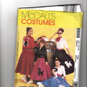 Puede incluir: Patrón de disfraces McCall's con personas vestidas con atuendos de los años 50. Los disfraces incluyen faldas caniche, camisas de bolos y una gramola. El patrón es para una talla mediana, con el número 8899 visible.