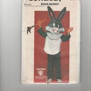 May include: A vintage sewing pattern for a Bugs Bunny costume. The pattern is from Butterick and is size one-size. The pattern features a cartoon image of Bugs Bunny holding a carrot.