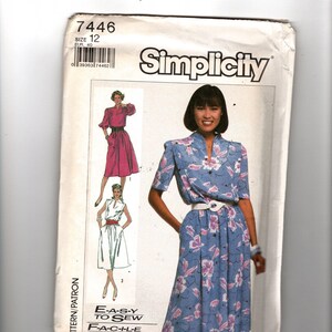 Puede incluir: Un patrón de costura Simplicity vintage, talla 12, con un diseño de vestido floral azul. El patrón incluye ilustraciones del vestido y el texto "EASY TO SEW". El paquete está ligeramente desgastado.