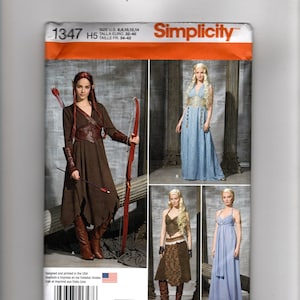 May include: Simplicity sewing pattern 1347 featuring four costume designs. View A shows a brown dress with a corset and arm guards. View B and C show long light blue dresses. View D shows a brown top and skirt. Includes U.S. sizes 6, 8, 10, 12, 14.