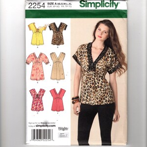 Puede incluir: Patrón de costura Simplicity 2254 para blusas, incluyendo un diseño de estampado de leopardo con ribete negro y otros estilos en amarillo, rosa y beige. Tallas disponibles: XS, S, M, L, XL. El logo de Simplicity es visible.