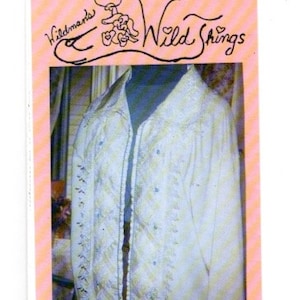 May include: A white jacket with a black zipper and a white and black embroidered design. The jacket has a Wildmans Wild Things label with the number SW101.