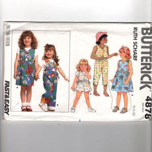 May include: A Butterick sewing pattern featuring children's clothing designs. The pattern includes images of dresses, overalls, and a romper, all in colorful, patterned fabrics. The text "Fast & Easy" is visible on the left side of the pattern.