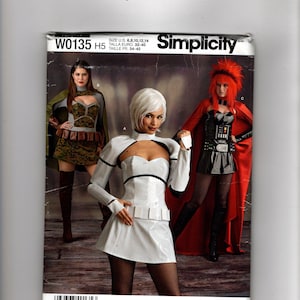 Peut inclure: Une pochette de patron de couture Simplicity W0135 H5 présentant trois modèles de costumes. Le devant montre trois personnes portant des tenues : une robe à motif camouflage avec une cape, une robe blanche futuriste et une robe noire avec une cape rouge.
