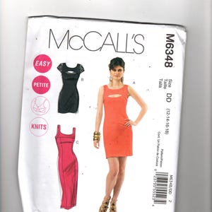 May include: McCall's M6348 sewing pattern featuring three dress designs. The pattern includes sizes DD (12-14-16-18). The image shows a woman wearing a coral-colored dress with a keyhole cutout.