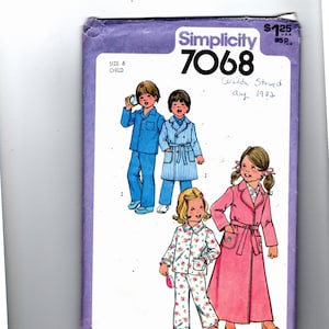 Puede incluir: Patrón de costura Simplicity número 7068 para pijamas y batas de niños. El patrón incluye tres estilos diferentes: un pijama azul con una camisa de manga larga y pantalones, una bata a rayas con una camisa de manga larga y un cinturón de atar, y una bata rosa con una camisa de manga larga y un cinturón de atar. El patrón es para un niño de talla 6.