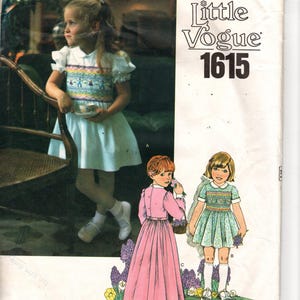 Può includere: Modello di cucito Little Vogue 1615 vintage. La copertina presenta una bambina in un vestito bianco con un corpetto ricamato colorato. Ulteriori illustrazioni mostrano altri due modelli di abiti, uno rosa e uno verde, con accenti floreali. Il modello è per abbigliamento per bambini.