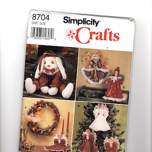 Könnte beinhalten: Ein Simplicity Crafts Schnittmusterpaket mit verschiedenen Weihnachtsbastelprojekten. Das Paket enthält Anleitungen zur Herstellung eines Stoffhasen, Engelsornamenten und eines festlichen Kranzes. Das Paket ist mit "8704" und "One Size" gekennzeichnet.