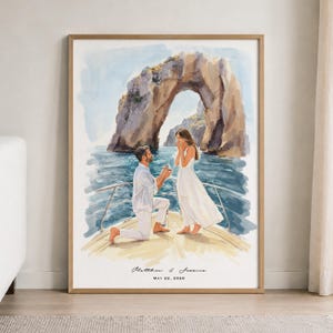 Op de afbeelding: Een ingelijste aquarelprint van een huwelijksaanzoek op een bootdek met een grote rotsboog op de achtergrond. Een persoon in het wit knielt om een ring aan te bieden. De tekst luidt: Matthew & Jessica, MAY 22, 2026.