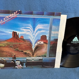 May include: An Al Stewart "Time Passages" vinyl record album. The album cover features a landscape scene with a window-like frame. The vinyl record is black and has the Arista label.