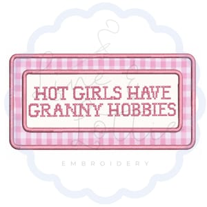 May include: A rectangular embroidered patch featuring a pink and white gingham border and a white center panel. The text HOT GIRLS HAVE GRANNY HOBBIES is stitched in pink thread across the center in a block-style font with a cross-stitch effect.