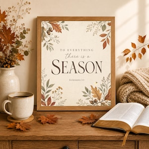 May include: A framed wall art print featuring the text TO EVERYTHING there is a SEASON Ecclesiastes 3:1. The design is decorated with watercolor illustrations of autumn leaves, branches, and acorns in shades of orange, brown, and green.