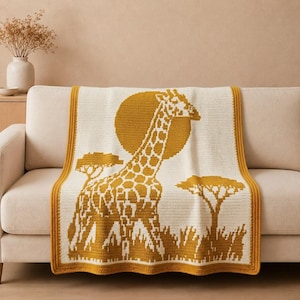 May include: A rectangular crochet blanket featuring a mustard yellow and cream colour scheme. The design displays a large giraffe standing in a savanna landscape with two acacia trees and a circular sun in the background, framed by a solid border.