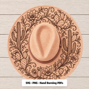 May include: A tan felt hat featuring a black line art design of cacti, prickly pears, and floral scrollwork on the brim. The hat has a matching tan band around the crown. The text "SVG • PNG • Hand Burning PDFs" is printed at the bottom.