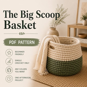 May include: A two-toned crochet basket featuring a cream-coloured upper section and a dark olive green base with integrated handles. A cream-coloured fringed throw blanket is draped over the side. Text reads The Big Scoop Basket PDF PATTERN.