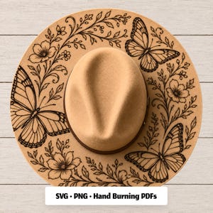 May include: A tan felt hat featuring a dark brown line art design of three butterflies surrounded by floral vines and leaves on the brim. The text SVG • PNG • Hand Burning PDFs is printed in black at the bottom of the image.