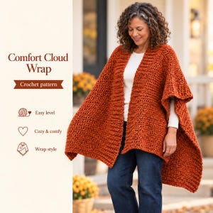 May include: A rust-colored, chunky crochet wrap worn over a white long-sleeve shirt and blue jeans. The text reads Comfort Cloud Wrap, Crochet pattern, Easy level, Cozy & comfy, and Wrap style, accompanied by icons of yarn, a heart, and a wrap.