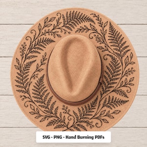 May include: A tan felt fedora hat featuring a dark brown leather band and a black line art design of fern leaves and small berries encircling the brim. The text SVG • PNG • Hand Burning PDFs is printed in black on a white rectangular label.