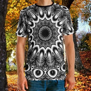 May include: A short-sleeve t-shirt featuring an all-over black and white fractal pattern. The design centers on a large, intricate circular mandala-like motif with radiating pointed shapes and detailed, repeating geometric textures throughout.