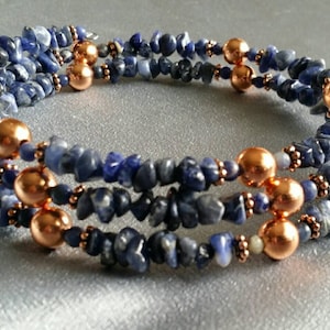 May include: A multi-strand bracelet made with blue and copper beads. The bracelet is made with small, irregular shaped blue stones and round copper beads.
