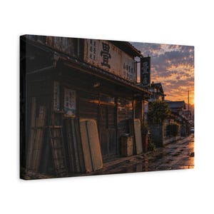 May include: A rectangular canvas print depicting a weathered wooden storefront in Japan at sunset. The building features Japanese kanji signage, including the character for tatami, with rectangular mats leaning against the exterior wall.