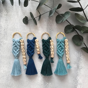 Personalized macramé keychains hand-woven from pure cotton cord. Available in a wide range of colors and featuring wooden bead accents, these keychains make a lovely gift for bridesmaids, the maid or matron of honor, flower girls, and the "bride tribe." They also add an elegant touch to bridesmaid proposal boxes.