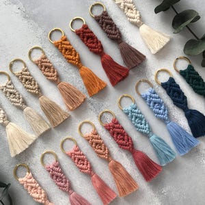 Personalized macramé keychains hand-woven from pure cotton cord. Available in a wide range of colors and featuring wooden bead accents, these keychains make a lovely gift for bridesmaids, the maid or matron of honor, flower girls, and the "bride tribe." They also add an elegant touch to bridesmaid proposal boxes.