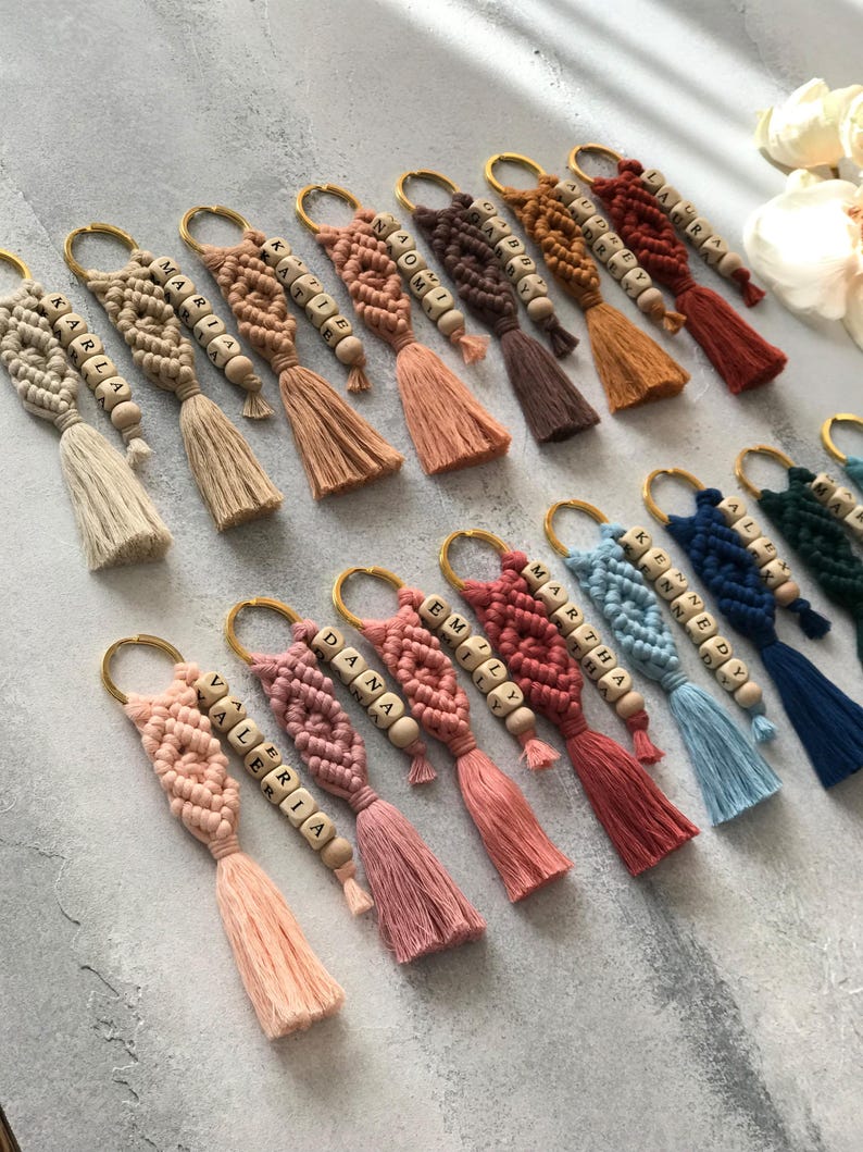 Personalized macramé keychains hand-woven from pure cotton cord. Available in a wide range of colors and featuring wooden bead accents, these keychains make a lovely gift for bridesmaids, the maid or matron of honor, flower girls, and the "bride tribe." They also add an elegant touch to bridesmaid proposal boxes.