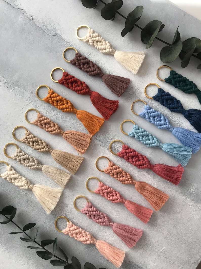 Personalized macramé keychains hand-woven from pure cotton cord. Available in a wide range of colors and featuring wooden bead accents, these keychains make a lovely gift for bridesmaids, the maid or matron of honor, flower girls, and the "bride tribe." They also add an elegant touch to bridesmaid proposal boxes.