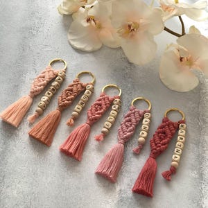 Personalized macramé keychains hand-woven from pure cotton cord. Available in a wide range of colors and featuring wooden bead accents, these keychains make a lovely gift for bridesmaids, the maid or matron of honor, flower girls, and the "bride tribe." They also add an elegant touch to bridesmaid proposal boxes.