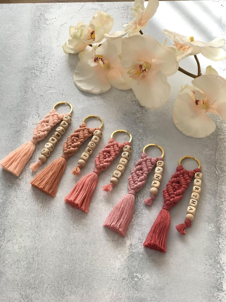 Personalized macramé keychains hand-woven from pure cotton cord. Available in a wide range of colors and featuring wooden bead accents, these keychains make a lovely gift for bridesmaids, the maid or matron of honor, flower girls, and the "bride tribe." They also add an elegant touch to bridesmaid proposal boxes.