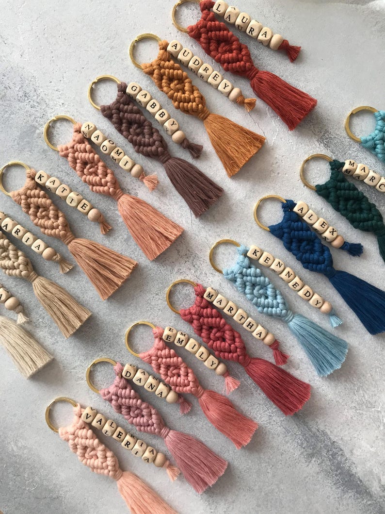 Personalized macramé keychains hand-woven from pure cotton cord. Available in a wide range of colors and featuring wooden bead accents, these keychains make a lovely gift for bridesmaids, the maid or matron of honor, flower girls, and the "bride tribe." They also add an elegant touch to bridesmaid proposal boxes.
