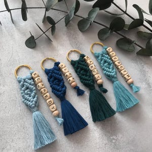 Personalized macramé keychains hand-woven from pure cotton cord. Available in a wide range of colors and featuring wooden bead accents, these keychains make a lovely gift for bridesmaids, the maid or matron of honor, flower girls, and the "bride tribe." They also add an elegant touch to bridesmaid proposal boxes.