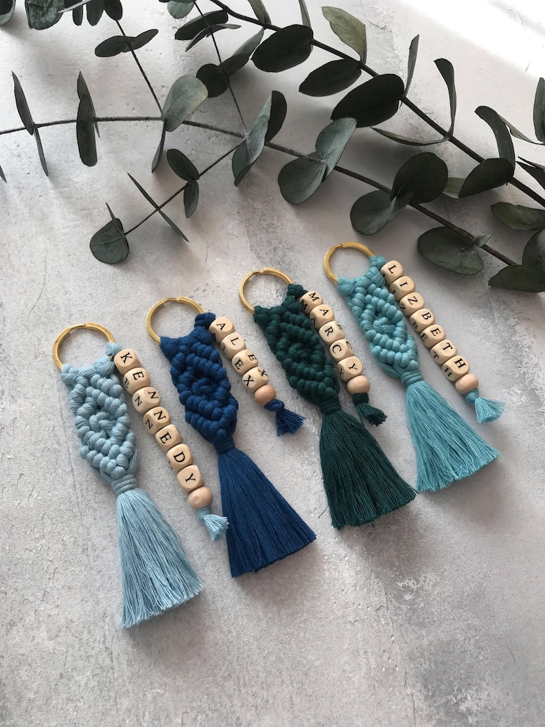 Personalized macramé keychains hand-woven from pure cotton cord. Available in a wide range of colors and featuring wooden bead accents, these keychains make a lovely gift for bridesmaids, the maid or matron of honor, flower girls, and the "bride tribe." They also add an elegant touch to bridesmaid proposal boxes.