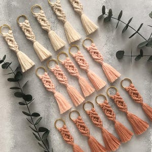 Personalized macramé keychains hand-woven from pure cotton cord. Available in a wide range of colors and featuring wooden bead accents, these keychains make a lovely gift for bridesmaids, the maid or matron of honor, flower girls, and the "bride tribe." They also add an elegant touch to bridesmaid proposal boxes.