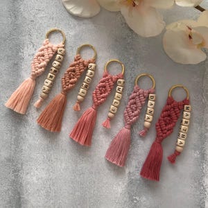 Personalized macramé keychains hand-woven from pure cotton cord. Available in a wide range of colors and featuring wooden bead accents, these keychains make a lovely gift for bridesmaids, the maid or matron of honor, flower girls, and the "bride tribe." They also add an elegant touch to bridesmaid proposal boxes.