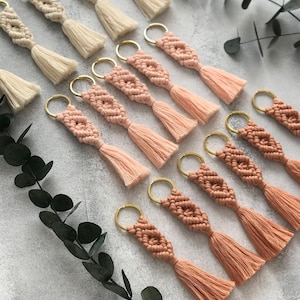 Personalized macramé keychains hand-woven from pure cotton cord. Available in a wide range of colors and featuring wooden bead accents, these keychains make a lovely gift for bridesmaids, the maid or matron of honor, flower girls, and the "bride tribe." They also add an elegant touch to bridesmaid proposal boxes.