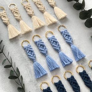 Personalized macramé keychains hand-woven from pure cotton cord. Available in a wide range of colors and featuring wooden bead accents, these keychains make a lovely gift for bridesmaids, the maid or matron of honor, flower girls, and the "bride tribe." They also add an elegant touch to bridesmaid proposal boxes.