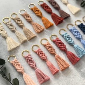 Personalized macramé keychains hand-woven from pure cotton cord. Available in a wide range of colors and featuring wooden bead accents, these keychains make a lovely gift for bridesmaids, the maid or matron of honor, flower girls, and the "bride tribe." They also add an elegant touch to bridesmaid proposal boxes.