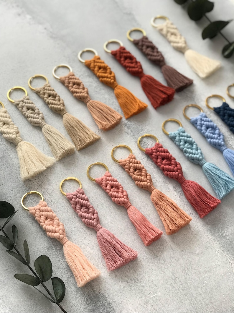 Personalized macramé keychains hand-woven from pure cotton cord. Available in a wide range of colors and featuring wooden bead accents, these keychains make a lovely gift for bridesmaids, the maid or matron of honor, flower girls, and the "bride tribe." They also add an elegant touch to bridesmaid proposal boxes.