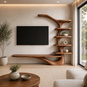 May include: A wall-mounted wooden media console and shelving unit with a natural grain finish. The structure features a long horizontal surface extending from a curved, tree-like vertical support with five stacked shelves holding small decor items.