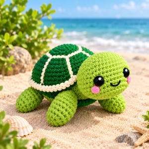 Op de afbeelding: Een gehaakt schildpadspeeltje met een lichtgroene kop en ledematen, voorzien van grote zwarte ogen en roze wangen. Het schild is donkergroen met crèmekleurige randen. De schildpad heeft een geborduurde glimlach en een textuurrijk haakpatroon.
