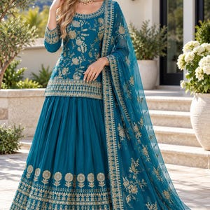 May include: A teal blue three-piece ensemble featuring a long-sleeved tunic and a floor-length skirt, both adorned with intricate gold floral embroidery. The outfit includes a matching sheer teal dupatta with a decorative gold embroidered border.