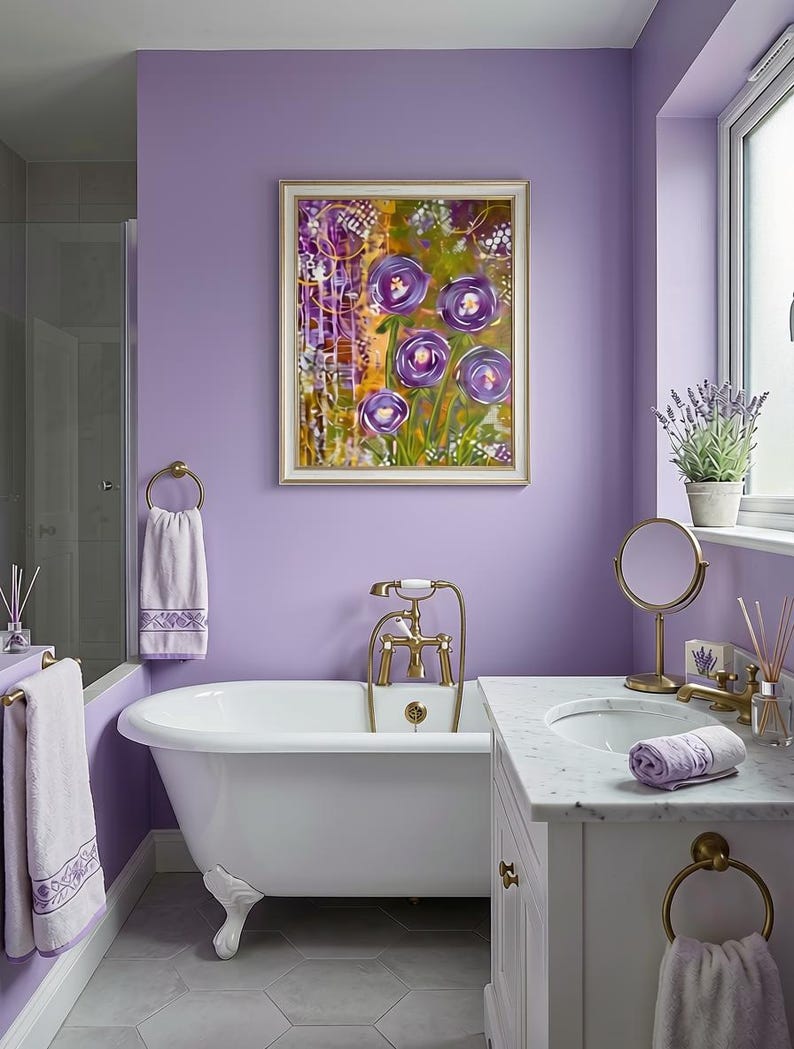 Op de afbeelding: Een ingelijst rechthoekig wandkunstwerk met een abstract bloemenschilderij met paarse bloemen, groen blad en gele accenten. Het kunstwerk hangt aan een lavendelkleurige muur boven een wit bad op pootjes met messing kranen.