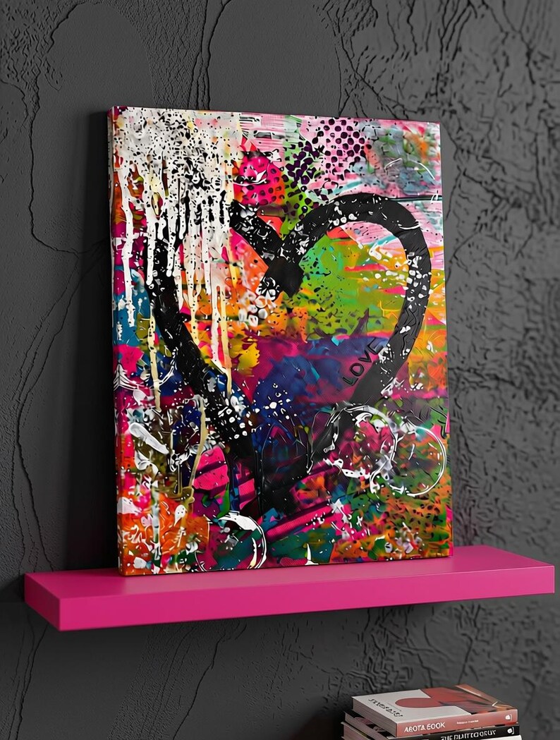 May include: A rectangular canvas wall art piece featuring a large, thick black painted heart shape over a vibrant, multi-colored abstract background of pink, orange, green, and blue paint splatters, with the word LOVE written in black.