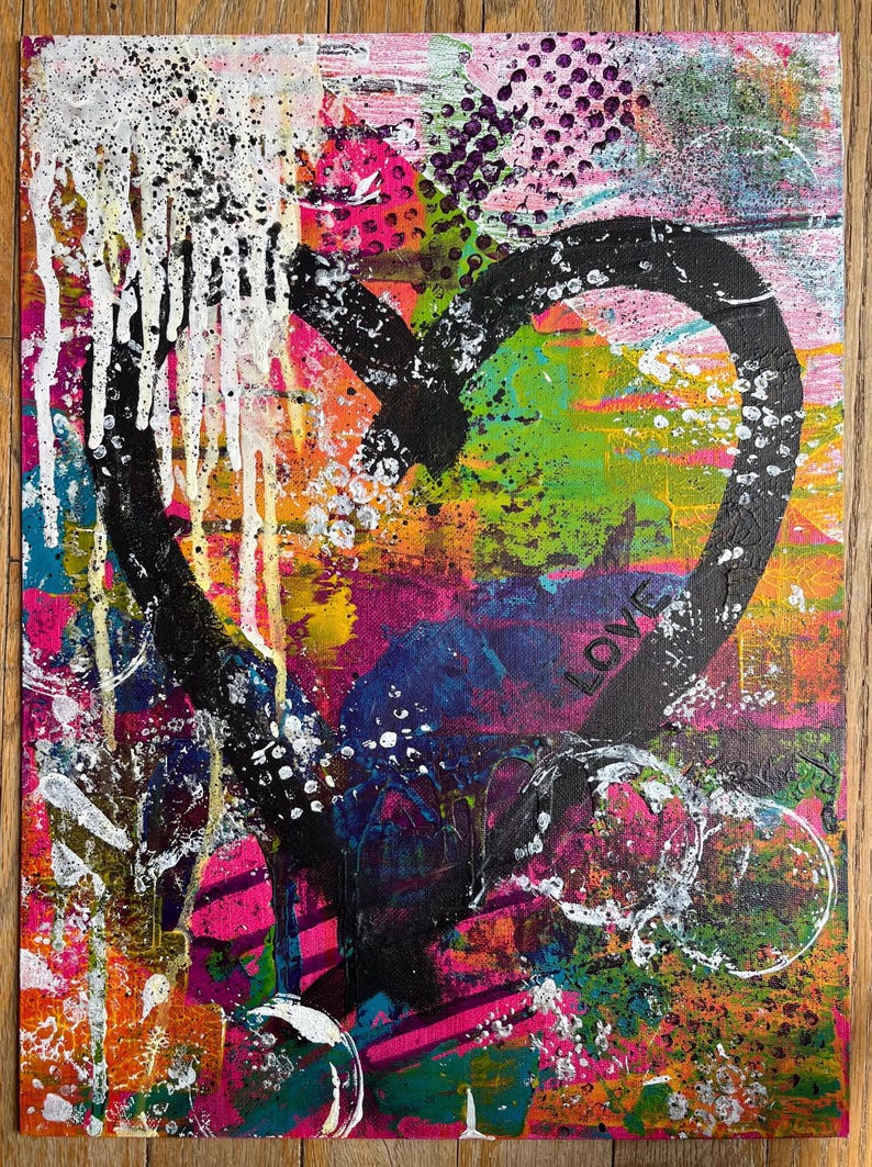 May include: A rectangular canvas painting featuring a large, thick black heart outline centered on a vibrant, multi-colored background. The artwork includes layers of pink, green, orange, and blue paint with white drips, splatters, and the word LOVE.