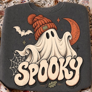 K&ouml;nnte beinhalten: Ein anthrazitfarbenes Sweatshirt mit Rundhalsausschnitt und einem Grafikdruck eines wei&szlig;en Geistes mit orangefarbener Strickm&uuml;tze. Das Design zeigt zudem eine fliegende Fledermaus, eine Mondsichel, ein Spinnennetz und das Wort SPOOKY in cremefarbenen Buchstaben.